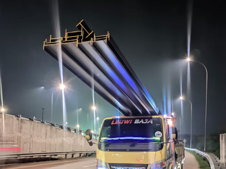 Truk Leuwi Baja mengangkut besi WF melintasi tol pada malam hari