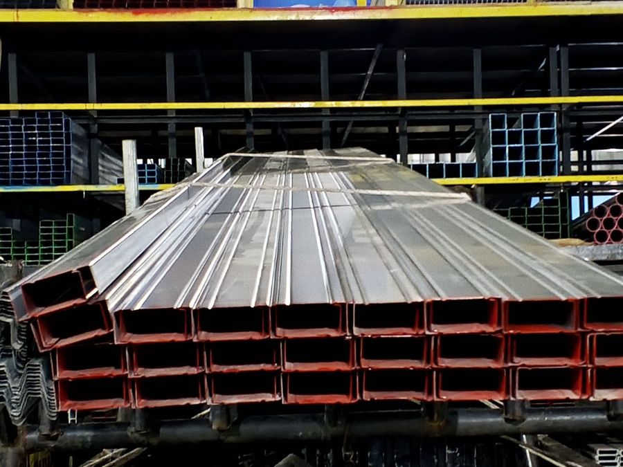Tumpukan CNP baja ringan berlapis cat merah tersimpan di gudang