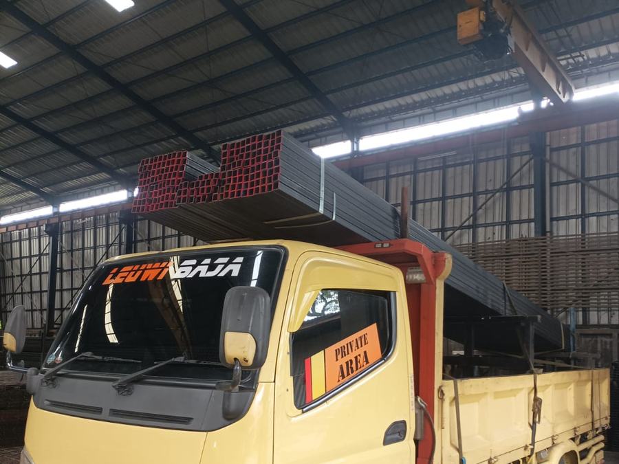 Truk memuat besi hollow merah dan hitam