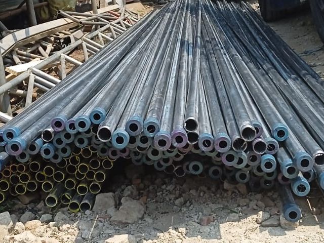 Tumpukan pipa besi dengan penampang bulat terlihat dari ujung